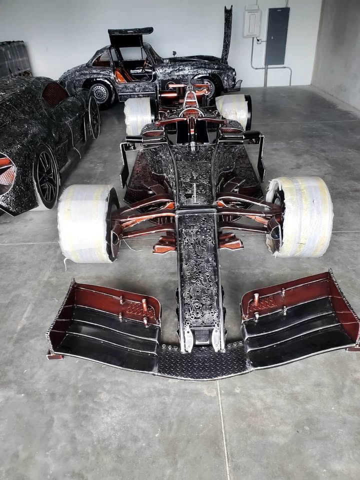 Full-scale F1-inspired recycled metal race car — front view with sculpted front wing