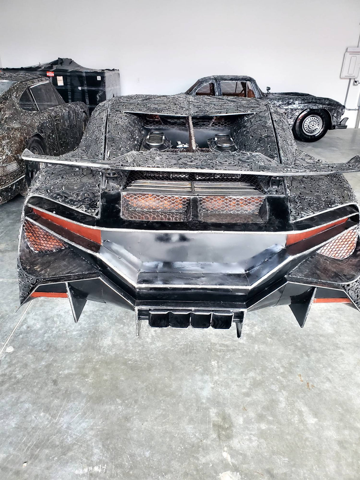 Chiron-inspired full-scale hypercar recycled metal sculpture, rear wing and taillight detail